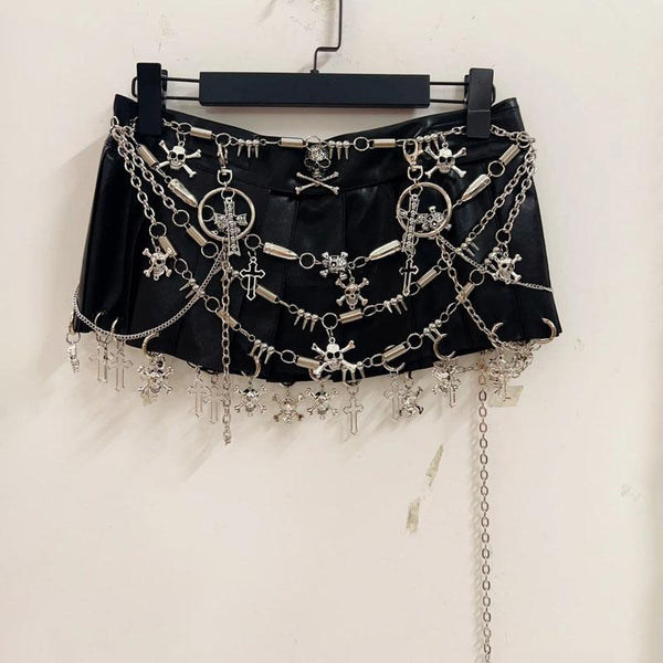 Minifalda plisada con apliques de calavera y anilla de cadena metálica 