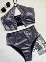 Traje de baño bikini con cuello halter, ahuecado, con aro metálico y lazo. 